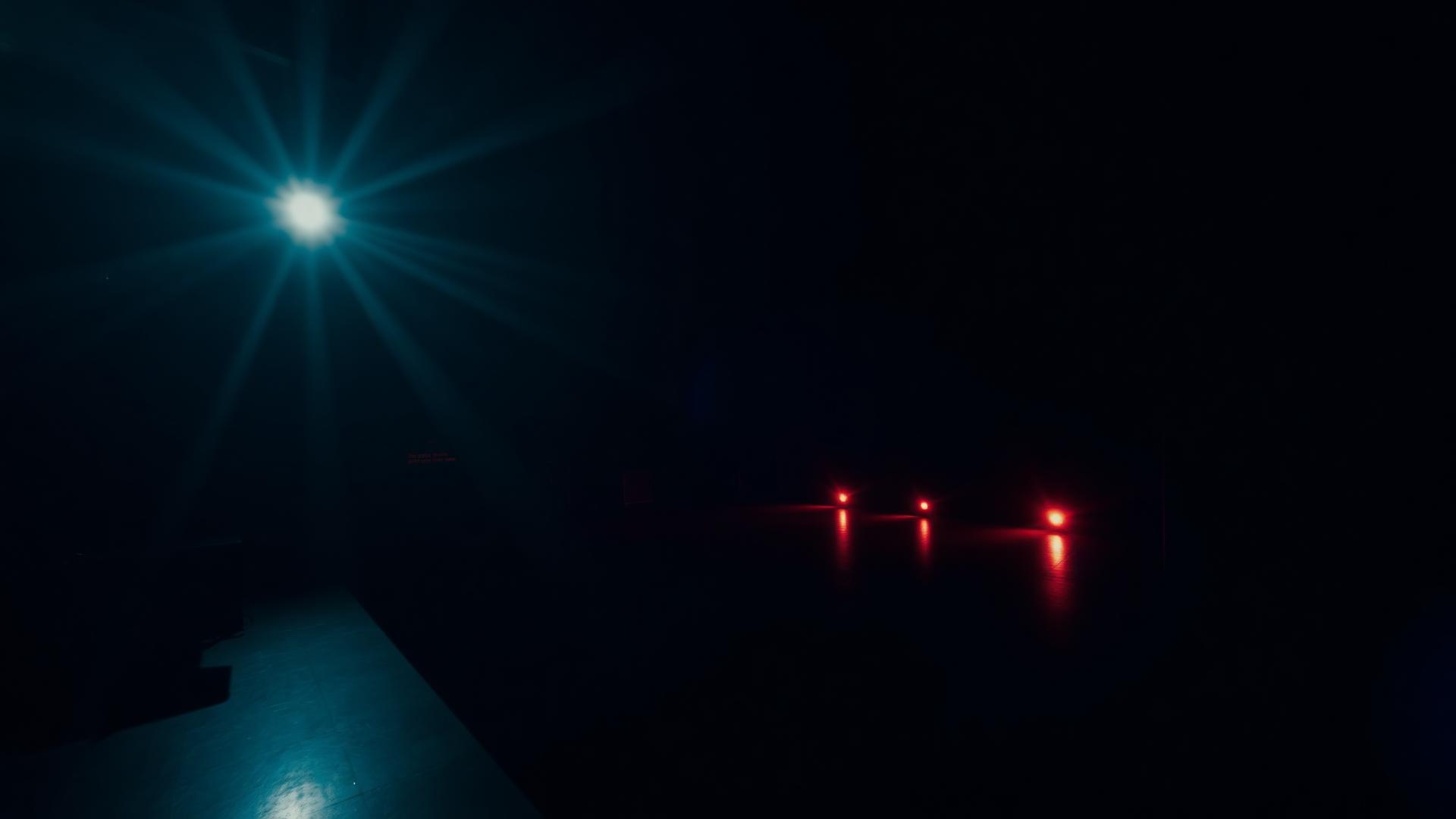 Dark cinematic grading studio with an anamorphic lens flare